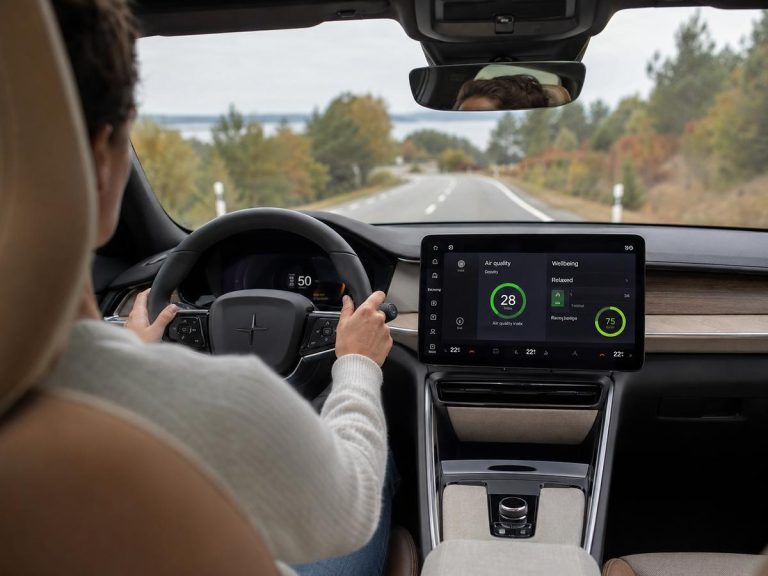 Conducteur détendu au volant d’une voiture électrique en 2026, habitacle naturel et sain avec qualité d’air affichée sur l’écran central.